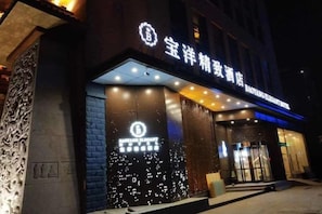 A hotel entrance with illuminated signage and a modern facade. - Baoyang Boutique Hotel (Shijiazhuang North Zhonghua Street Zhongchu Plaza) (Shijiazhuang)