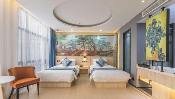 A hotel room with two beds, a desk, a chair, and a large mural on the wall. - Baoyang Boutique Hotel (Shijiazhuang North Zhonghua Street Zhongchu Plaza) (Shijiazhuang)