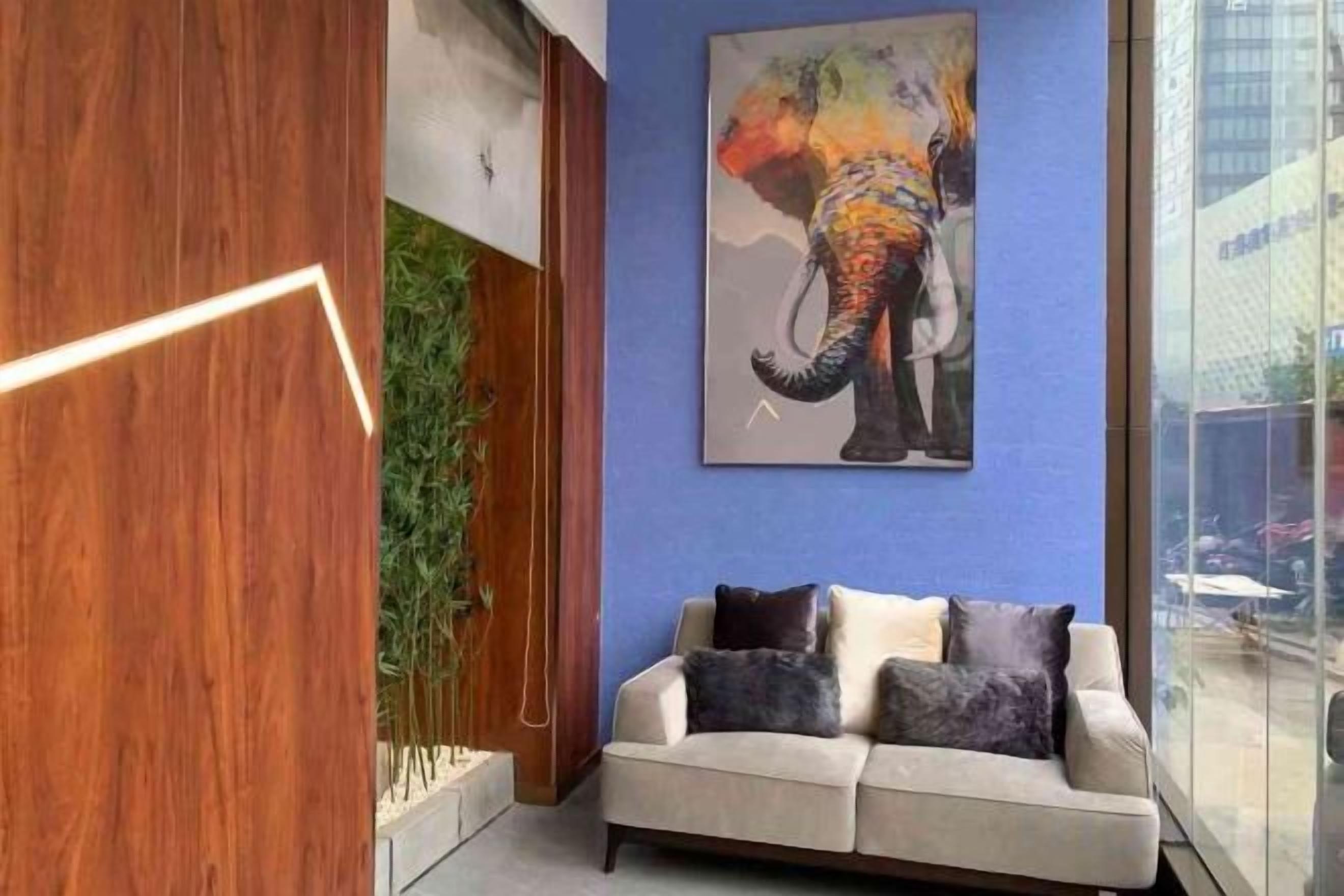 Um interior moderno com um sofá, uma pintura de um elefante e uma estrutura de madeira.