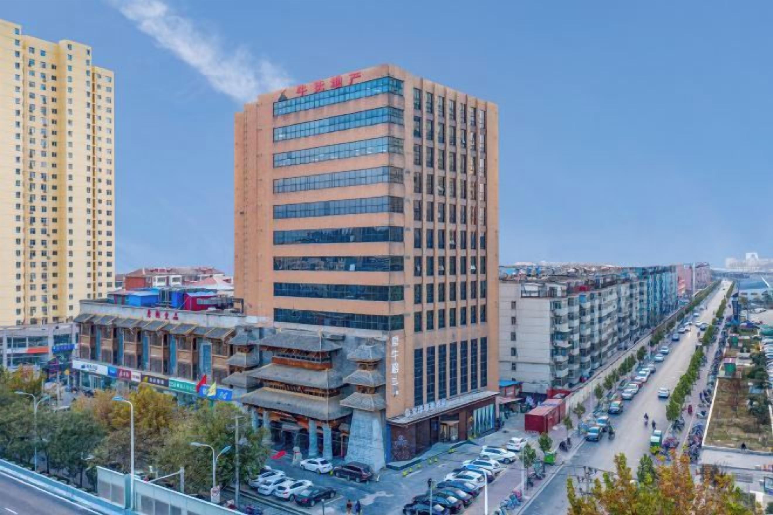Un edificio de varios pisos con fachada moderna, junto a un edificio tradicional con entrada visible.