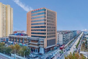 A multi-story building with a modern facade, adjacent to a traditional building with a visible entrance. - Baoyang Boutique Hotel (Shijiazhuang North Zhonghua Street Zhongchu Plaza) (Shijiazhuang)