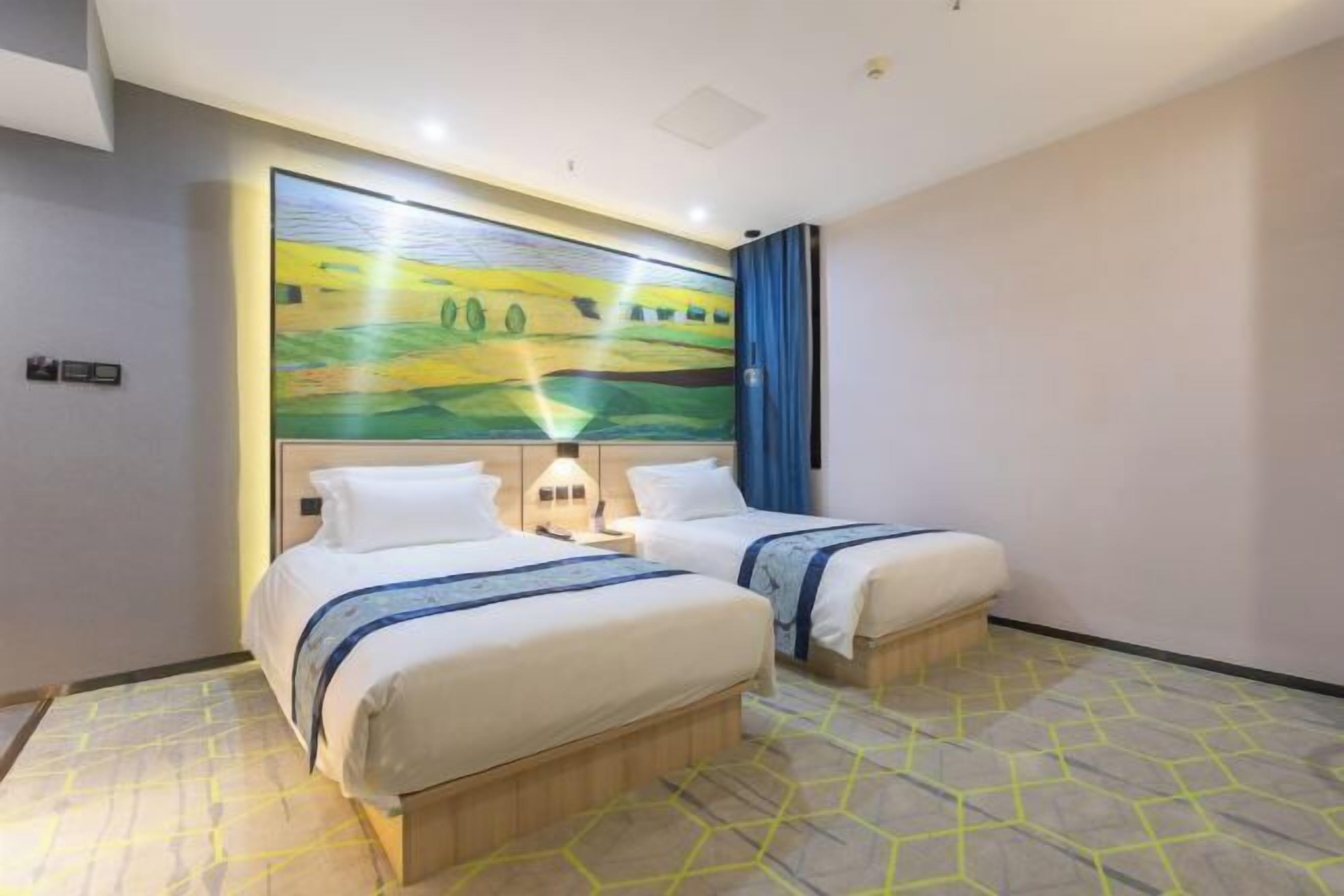 Une chambre d’hôtel avec deux lits, une grande peinture abstraite au mur et un sol orné d’un motif géométrique.