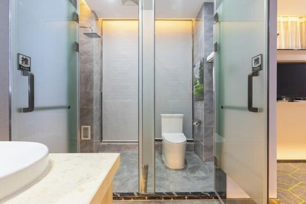 A modern bathroom with a glass-enclosed shower, a white toilet, and a marble countertop. - Baoyang Boutique Hotel (Shijiazhuang North Zhonghua Street Zhongchu Plaza) (Shijiazhuang)