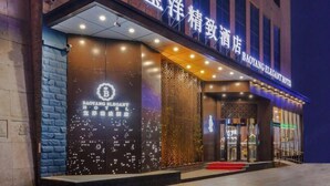 A hotel entrance with a modern facade, illuminated signage, and a red carpet leading to the door. - Baoyang Boutique Hotel (Shijiazhuang North Zhonghua Street Zhongchu Plaza) (Shijiazhuang)