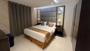 Una camera d'albergo moderna con un letto grande, un comodino, un armadio e uno specchio.