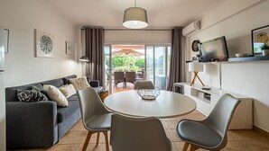 Un soggiorno moderno con un divano, poltrone, un tavolo da pranzo e una televisione.
