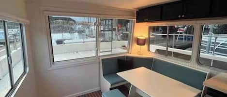A compact kitchen with a dining area, large windows, and a view of the outside.