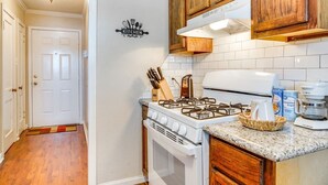 A kitchen with wooden cabinets, a white stove, and a coffee maker.