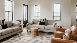 Un salon spacieux avec deux canapés, une table basse et un tapis.