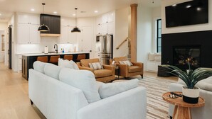 Un salon moderne avec un canapé, des fauteuils et une table basse.