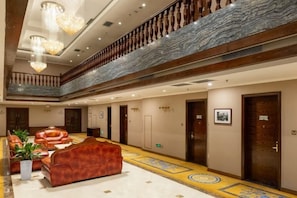 A hotel lobby with a central seating area, a marble staircase, and a high ceiling with chandeliers. - Xingzhengyuan International Hotel (Xi'an)
