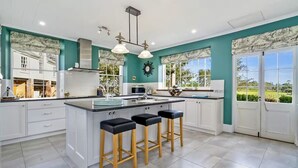 A modern kitchen with a central island, white cabinetry, and a view of the outdoors.
