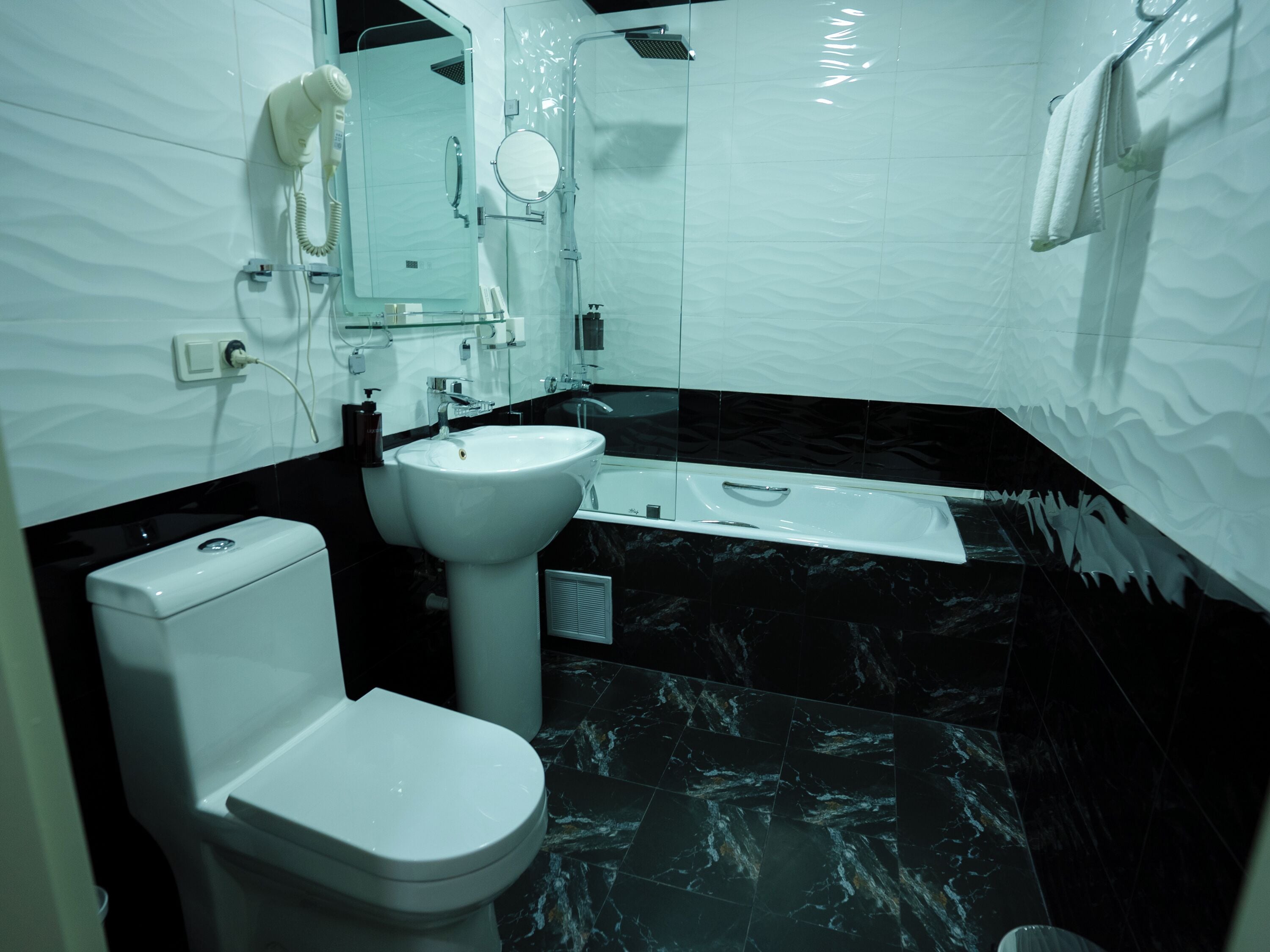 A modern bathroom with a toilet, sink, and bathtub.