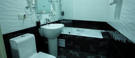 Et moderne badeværelse med toilet, vask og badekar.