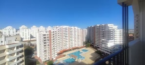 A high-rise residential building with multiple balconies, a swimming pool, and a clear blue sky. - Apartment 'T2 Edificio Cruzeiro' with Private Pool, Wi-Fi and Air Conditioning (Portimão)