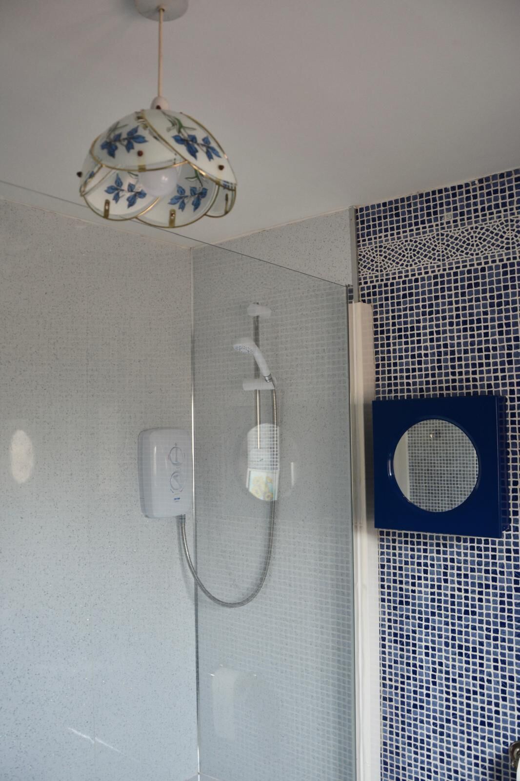 Een badkamer met een douche, toilet en wastafel.