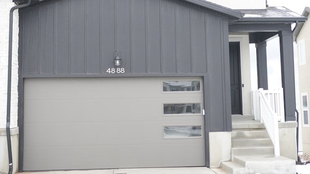 A two-story house with a garage, a visible address number, and a covered porch. - Modern Mapleton Retreat (Spanish Fork)