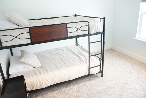 A bunk bed with a wooden headboard and a lower bed with a white mattress. - Modern Mapleton Retreat (Spanish Fork)