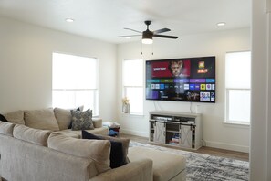 Relax in this stylish living room with a large flat-screen TV, comfortable sofa, and entertainment unit.