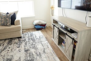 Relax in this stylish living room with a comfortable sofa, flat-screen TV, and a wooden cabinet.