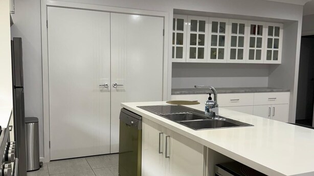 A modern kitchen with white cabinetry, a stainless steel sink, and a dishwasher. - Modern Luxury with Nature (Spring Farm)