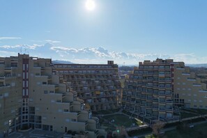 A high-rise residential building with multiple balconies, a central courtyard, and a clear view of the surrounding landscape. - SE139 – Senigallia, studio flat with terrace at the Piramidi residence (Senigallia)