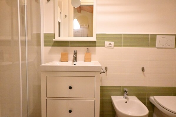 A bathroom with a sink, mirror, and bidet. There are two drawers and a cabinet below the sink. - Villa Aurora - Osimo, new villa with swimming pool (Osimo)