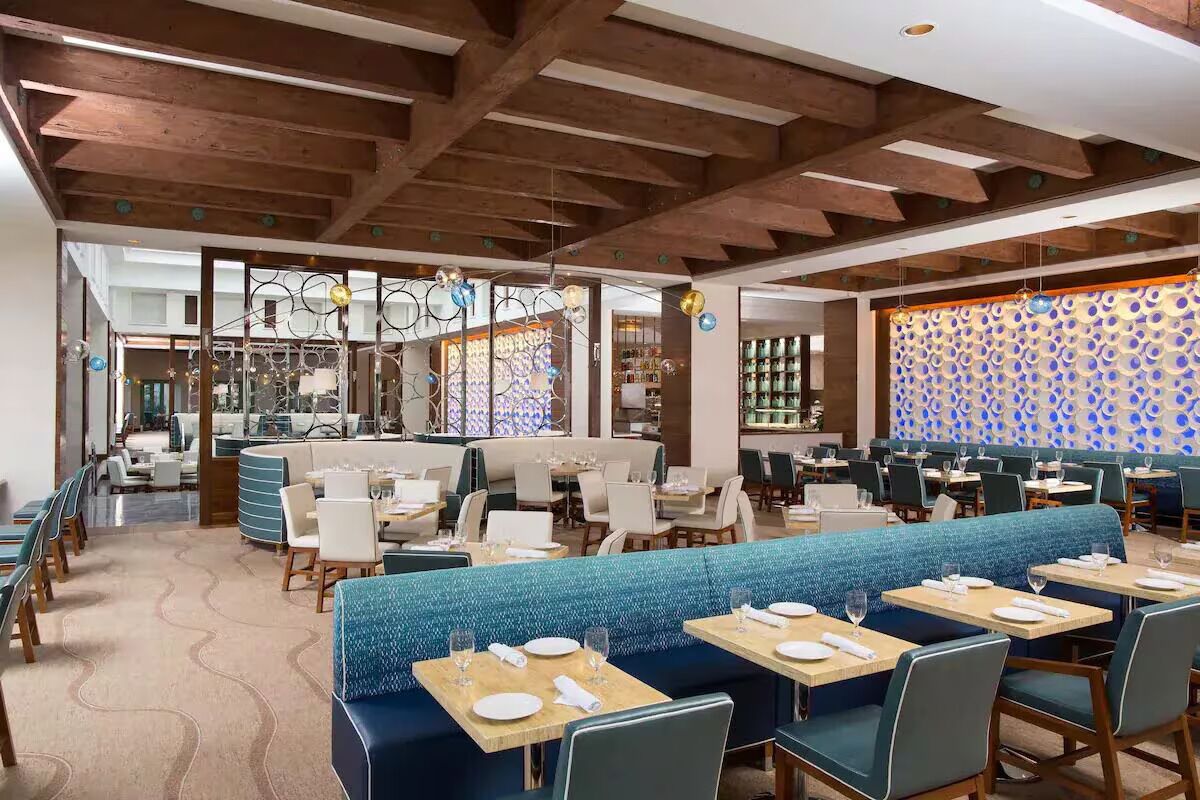 A restaurant with booths, tables, and a patterned wall.