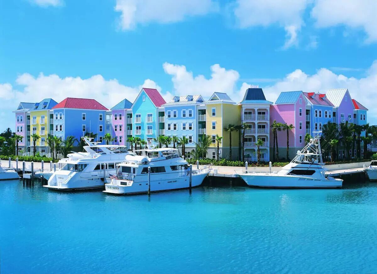 A marina with colorful buildings and yachts docked.