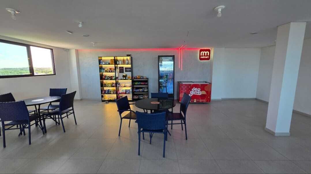 Ein moderner Innenraum mit Essbereich, einer Getränkeausgabe und einem Kühlschrank.