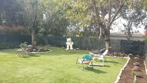 A backyard with a grassy lawn, a swing set, and a garden with various plants. - Villa "Domus Roma" - Room Piazza Navona (Roma)