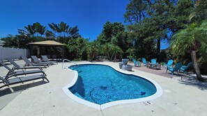 A swimming pool with lounge chairs and a gazebo. - Walk to the Beach (Sarasota)