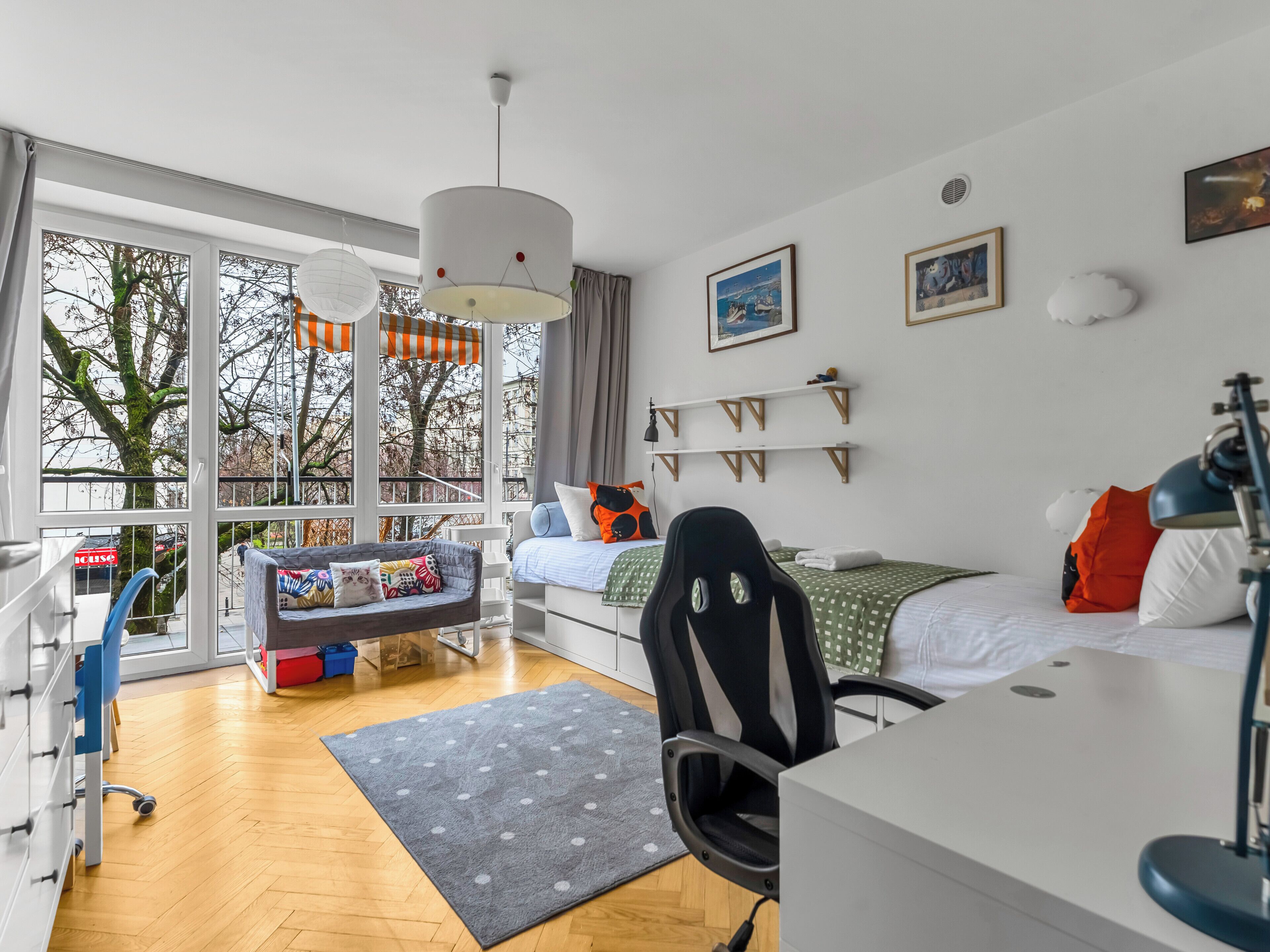 Een moderne slaapkamer met een groot raam, een bureau, een stoel en een bed.