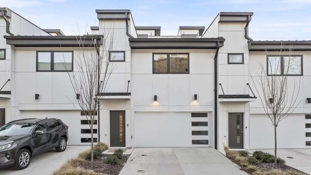 A modern residential building with a garage, a driveway, and a parked SUV. - Spacious Studio Suite, Downtown Durham (Durham)