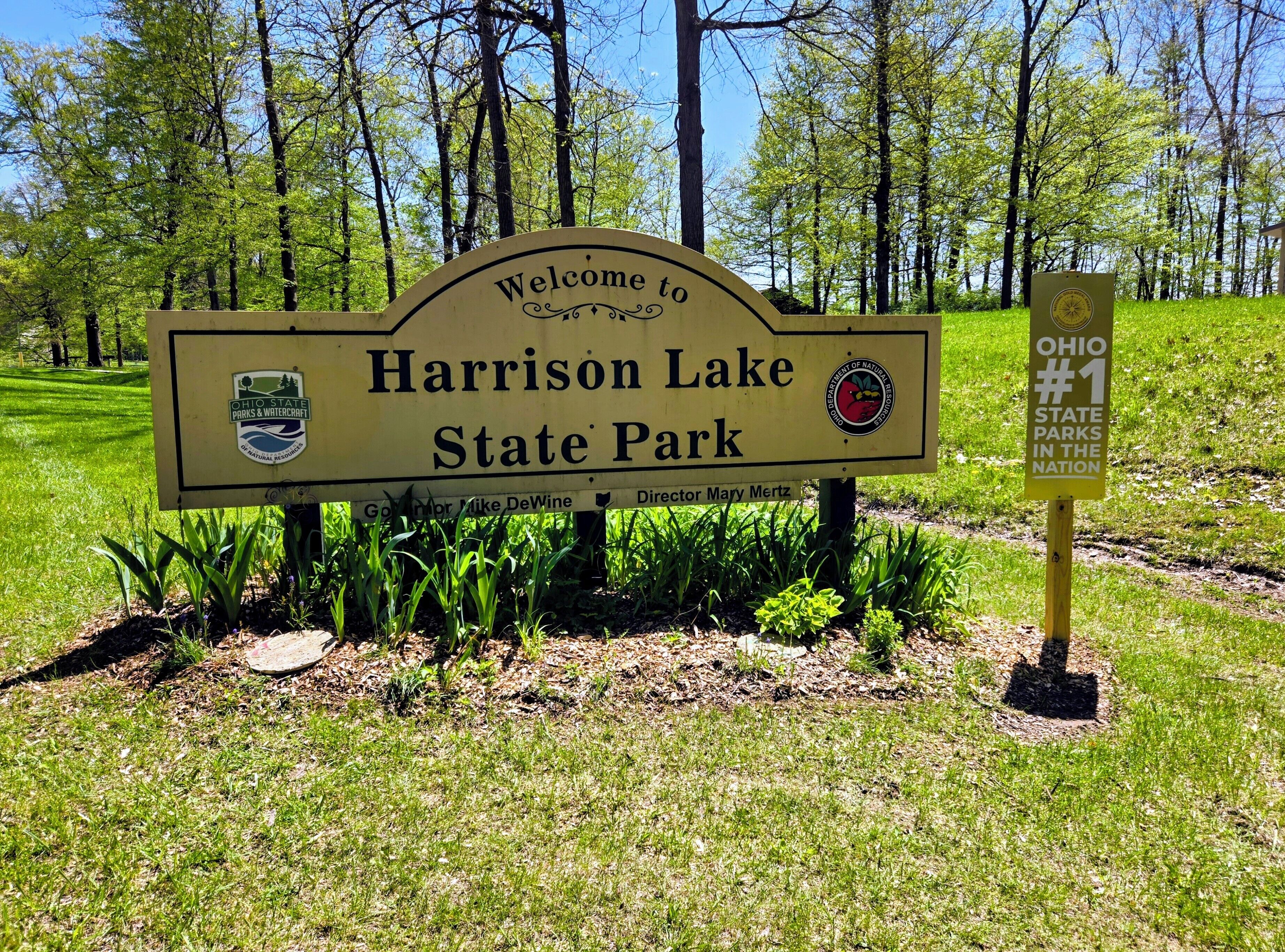 Letrero de bienvenida al Parque Estatal Harrison Lake con el logotipo de Parques Estatales y Embarcaciones de Ohio.