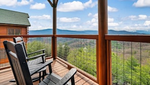 A wooden deck with a view of mountains and greenery. - Top of the World: Summer deals-Theater-hot tub-arcade games-million dollar views (Sevierville)