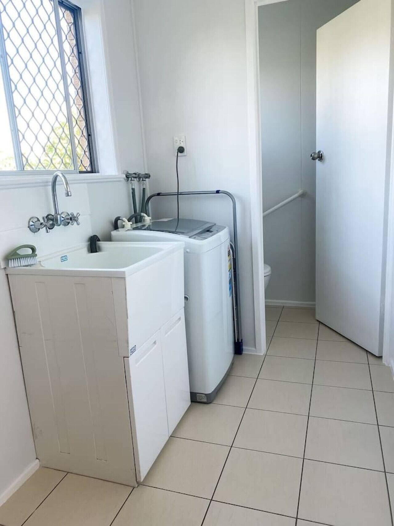 A laundry area with a washing machine, a dryer, and a sink.