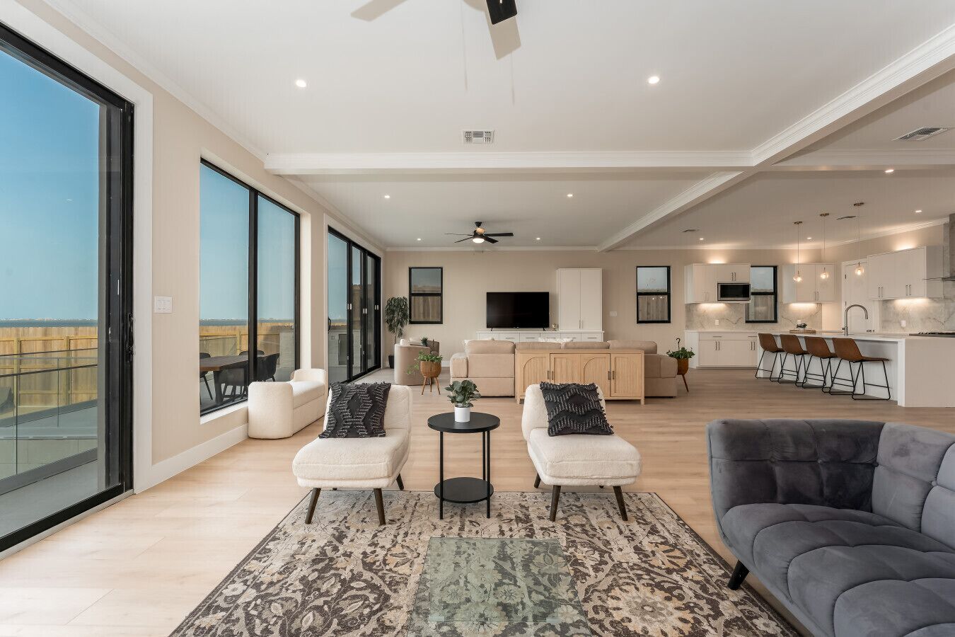 A spacious living area with a balcony, a kitchen, and a dining area.