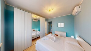 Ein modernes Schlafzimmer mit einem großen Bett, einem Kleiderschrank und einem Spiegel.