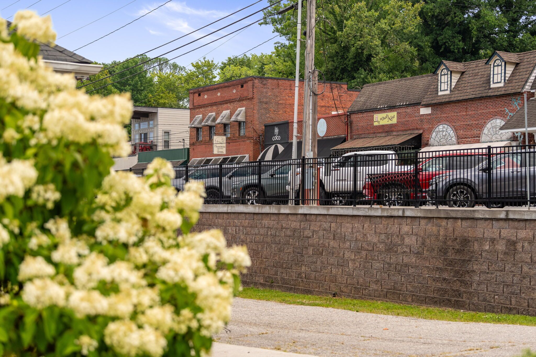 A parking area with cars and a brick building in the background.
