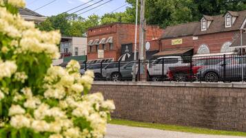A parking area with cars and a brick building in the background.