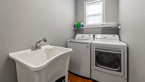 A laundry room with a sink, two washing machines, and a dryer. - *Box Car*Downtown Blue Ridge|Southern Charm Suites (Blue Ridge)