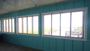 Ein Zimmer mit türkis-blauen Wandverkleidungen und großen Fenstern.