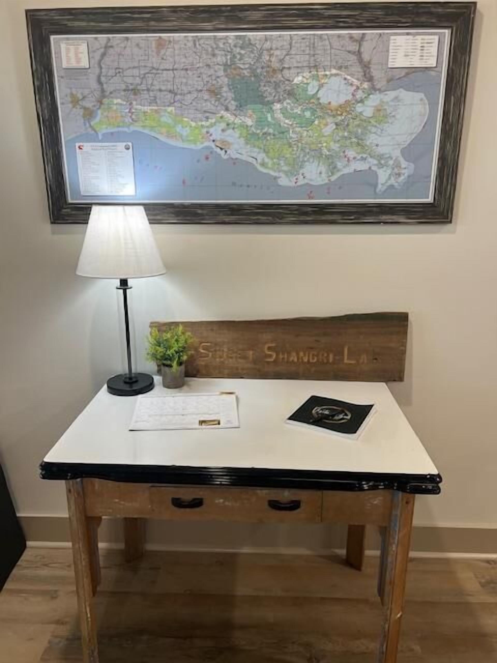 A desk with a map, a lamp, a small plant, and a sign reading "Street Shanghai."