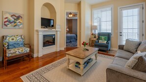 A living room with a fireplace, a television, a sofa, and a coffee table.