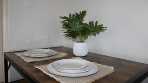 A dining table with plates and a potted plant.