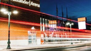 Un edificio con un cartello che riporta la scritta "Santander Arena" di sera.