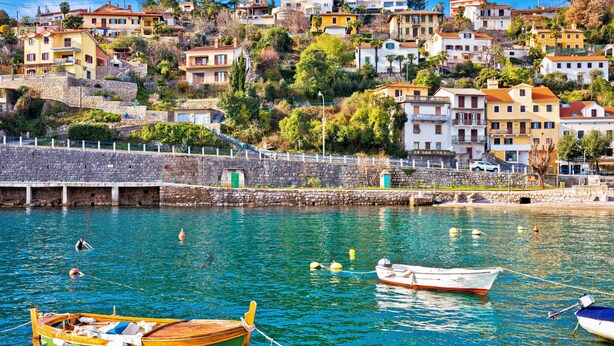 A coastal town with buildings on a hillside, a stone wall, and boats in the water. - Villa Nika by Interhome (Opatija/Ika)