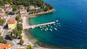 An aerial view of a coastal town with a marina, clear turquoise waters, and buildings with red-tiled roofs. - Villa Nika by Interhome (Opatija/Ika)