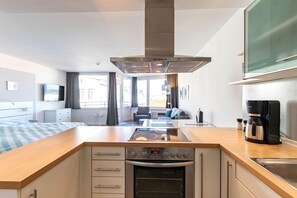 Eine moderne Küche mit Einbauherd, Backofen und Kaffeemaschine.